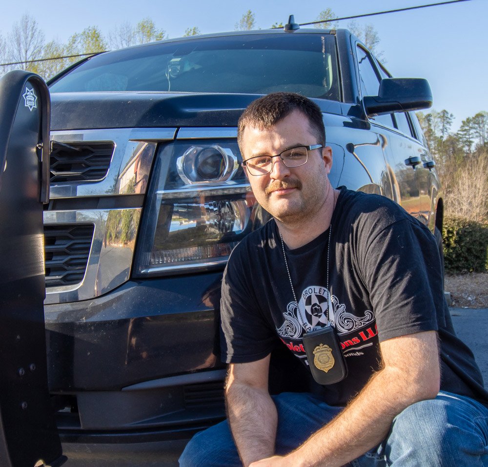 Ryan Drolet of Drolet Bonding poses for a photograph in front of his Chevrolet Tahoe as a bail bondsman in Spartanburg SC.